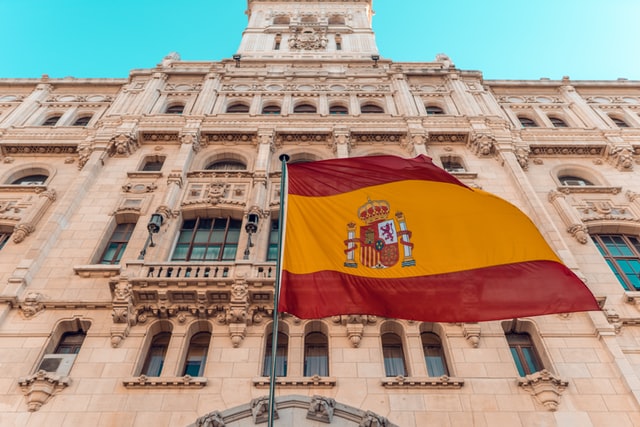 spanish building behind spanish flag
